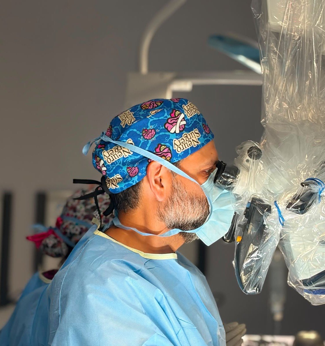 Neurocirujano realizando procedimiento microquirúrgico avanzado en quirófano en Ciudad Juárez.